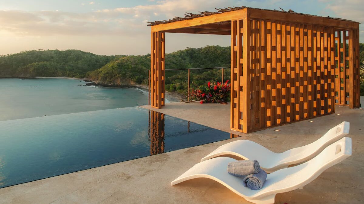 Costa Rica infinity pool over rainforest with Pacific view at sunset.